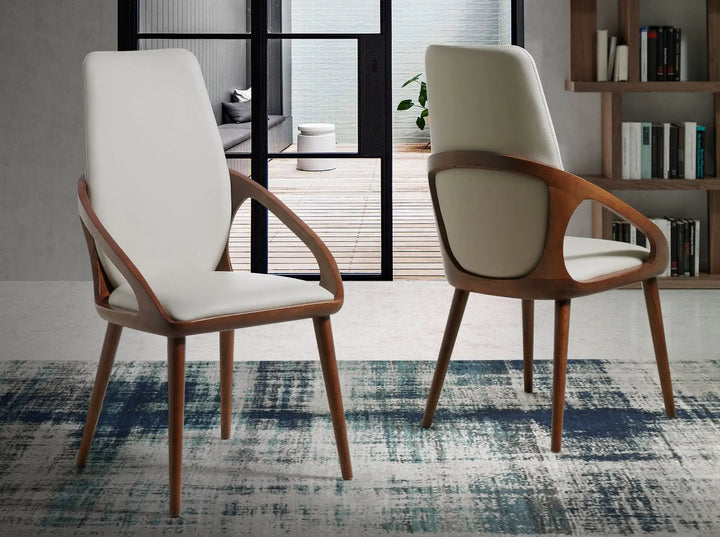 Silla de diseño moderno con asiento y respaldo tapizados en polipiel color crema.