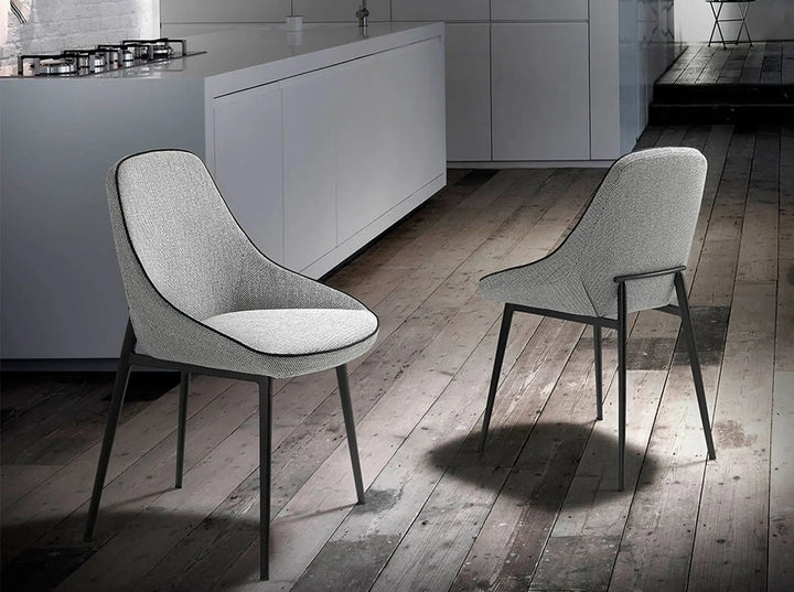 Silla de diseño moderno con asiento y respaldo tapizados en tela color gris.