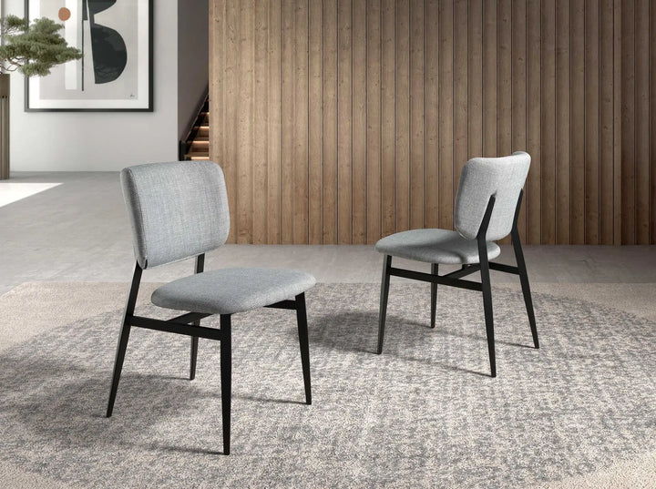 Silla de diseño moderno con asiento y respaldo tapizados en tela color gris claro.