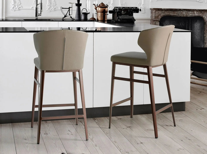 silla alta para barra o isla con asiento y respaldo tapizados en tono beige claro y patas delgadas de madera