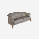 sofá estilo chester en gris claro con tapizado capitonado y patas de madera natural