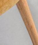 Sillón tapizado color mostaza, con patas en madera de pino