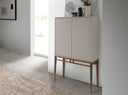 Aparador alto de diseño moderno con estructura de madera de MDF color beige y unas originales patas de madera chapada en nogal natural. 
