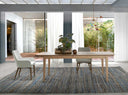 Silla reposabrazos de diseño moderno con asiento y respaldo tapizados en tela color beige. 