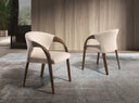 Silla con reposabrazos moderno con asiento y respaldo tapizados en tela color crema.