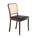 Silla de diseño moderno con asiento tapizado en polipiel color negro y respaldo de rattán.
