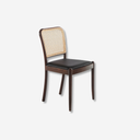 Silla de diseño moderno con asiento tapizado en polipiel color negro y respaldo de rattán.