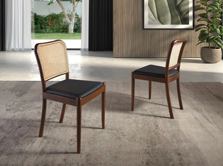 Silla de diseño moderno con asiento tapizado en polipiel color negro y respaldo de rattán.
