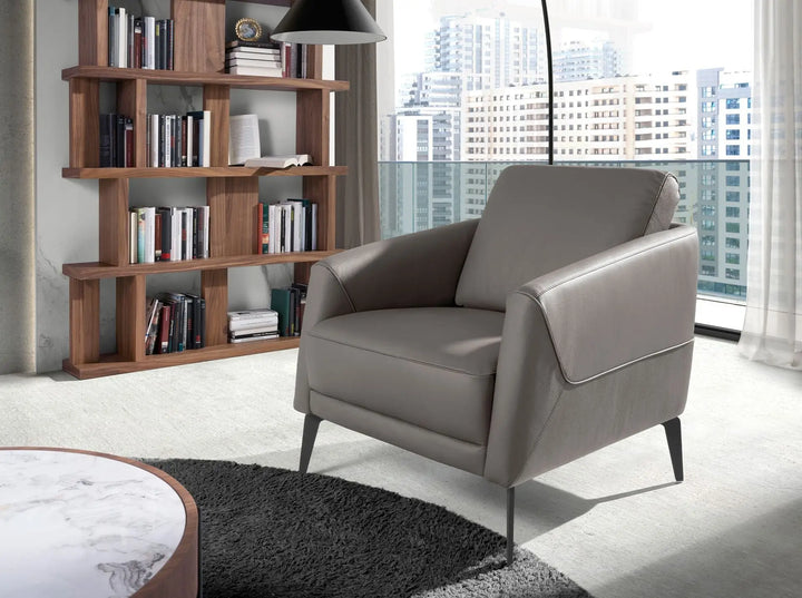 butaca elegante de piel gris topo con diseño minimalista y patas negras delgadas de metal

