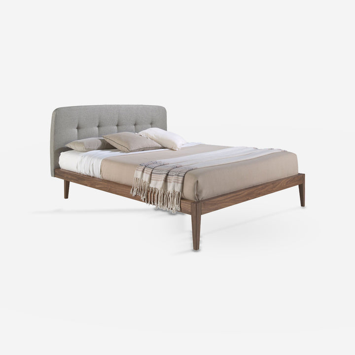 Cama capitoné tela color gris sobre fondo gris de estudio