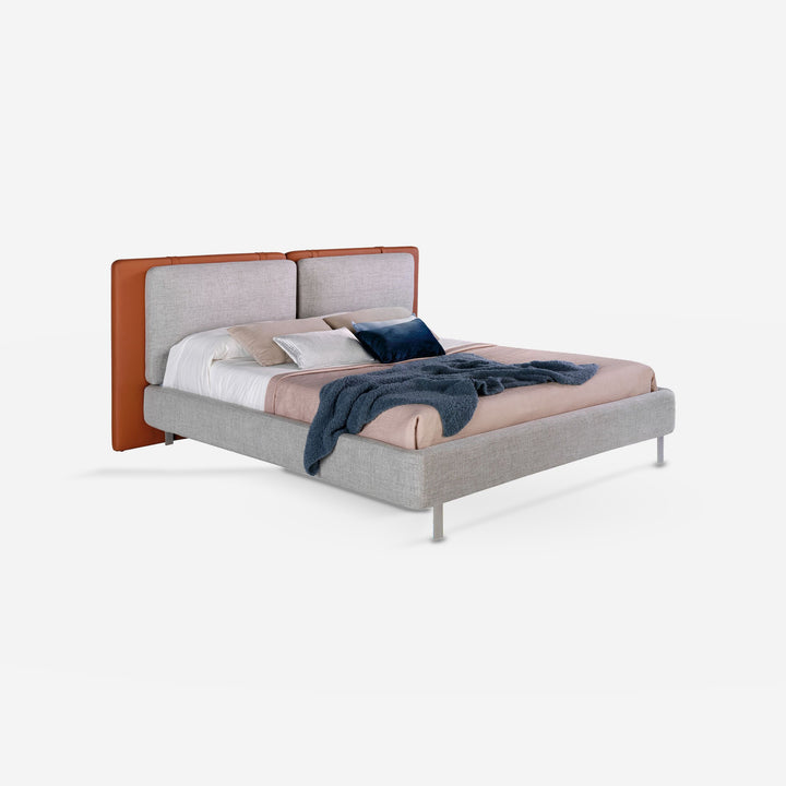 Cama polipiel color marrón y tela color gris sobre fondo gris de estudio