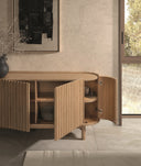 Aparador de madera maciza natural con frente de lamas y cuerpo curvo, 160 cm en ambiente decorado (3)