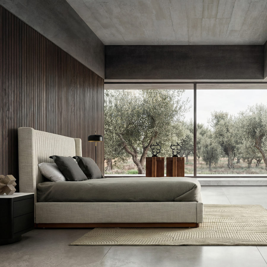 Habitación con cama tapizada y vistas al jardín