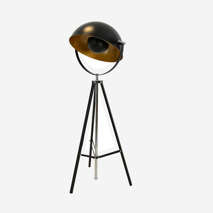 Lámpara de pie trípode regulable acero negro y pantalla dorada sobre fondo gris de estudio