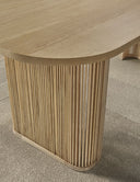 Detalle de la pata de lamas verticales de madera y del canto redondeado del tablero