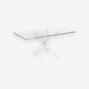 Mesa comedor rectangular de cristal templado con patas de acero en aspa acabado blanco, sobre fondo gris de estudio