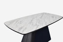 Mesa de comedor en laminado de mármol blanco con base de metal negro sobre fondo gris de estudio