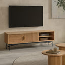 Mueble de TV de roble laminado natural y patas de metal en ambiente decorado