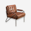 Sillón piel marrón coñac sobre fondo gris de estudio