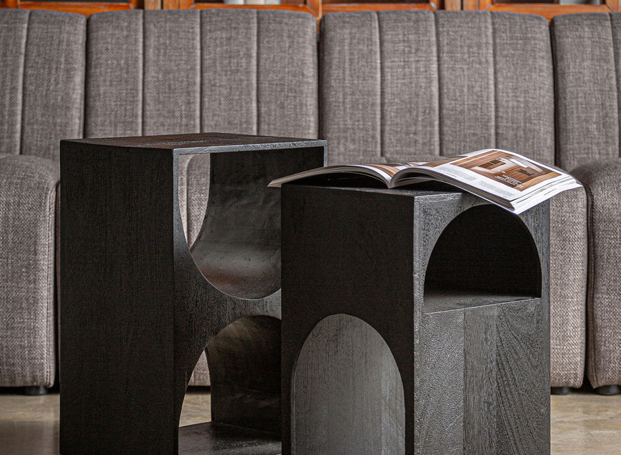 Brutalist side tables carved from solid blocks of black wood