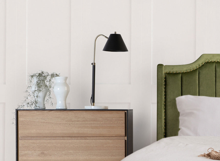 Scandinavian bedroom with pale wood chest of drawers, white wall and black task lamp