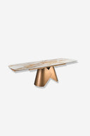 Mesa comedor extensible ovalada barril mármol porcelánico y acero color bronce sobre fondo gris de estudio