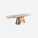 Mesa comedor extensible ovalada barril mármol porcelánico y acero color bronce sobre fondo gris de estudio