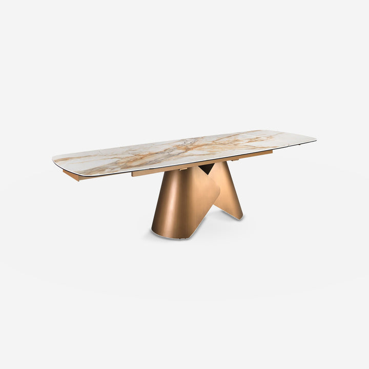 Mesa comedor extensible ovalada barril mármol porcelánico y acero color bronce sobre fondo gris de estudio