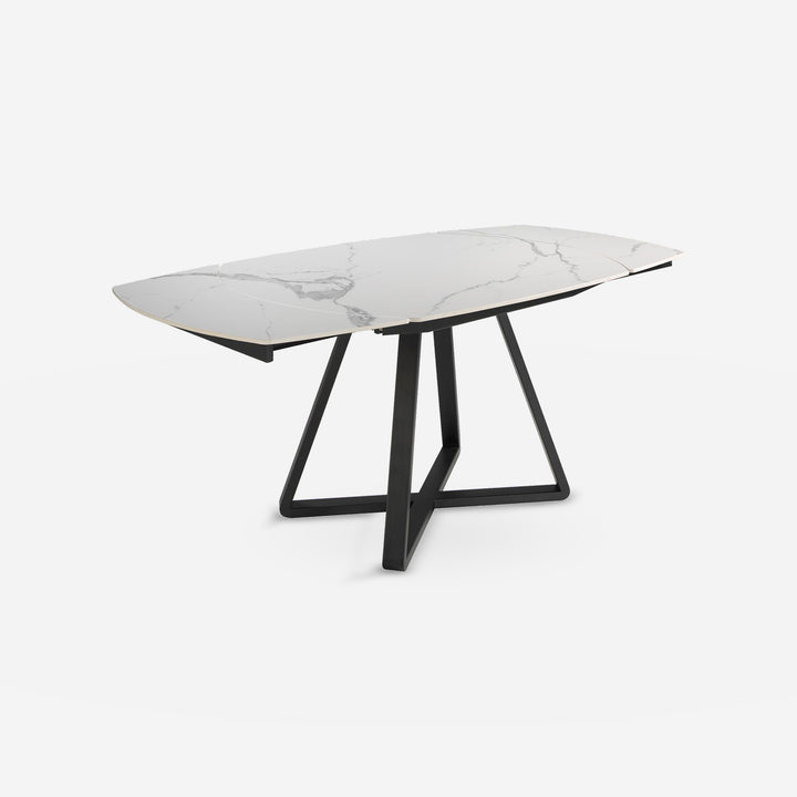 Mesa comedor extensible ovalada barril mármol porcelánico y acero negro sobre fondo gris de estudio