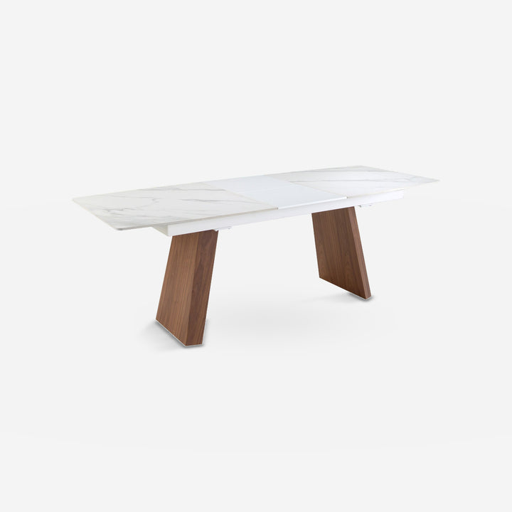 Mesa comedor extensible ovalada barril mármol porcelánico y nogal sobre fondo gris de estudio