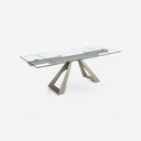 Mesa comedor extensible rectangular cristal templado y acero color champagne sobre fondo gris de estudio