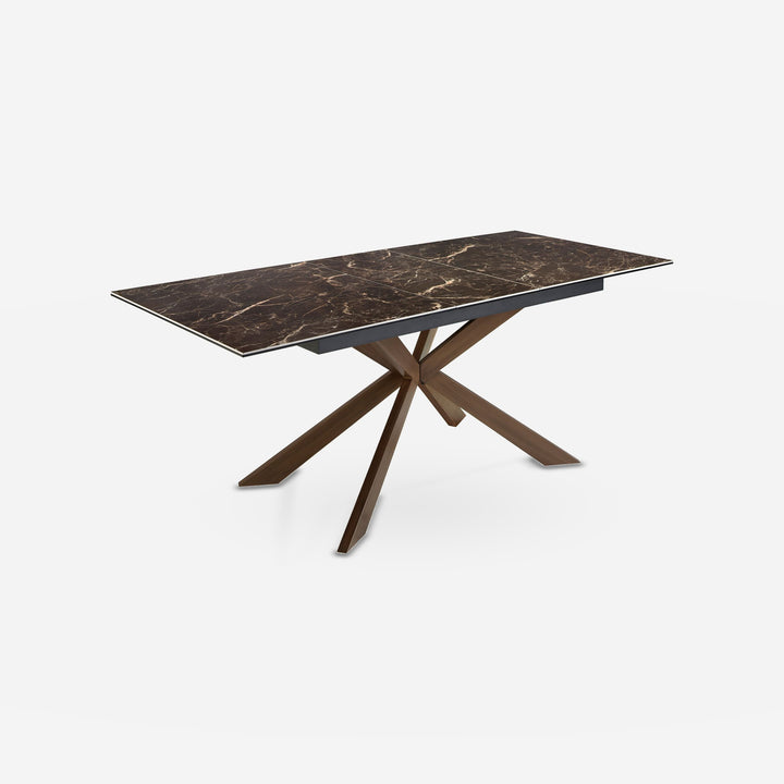 Mesa comedor extensible rectangular mármol porcelánico y acero efecto nogal sobre fondo gris de estudio