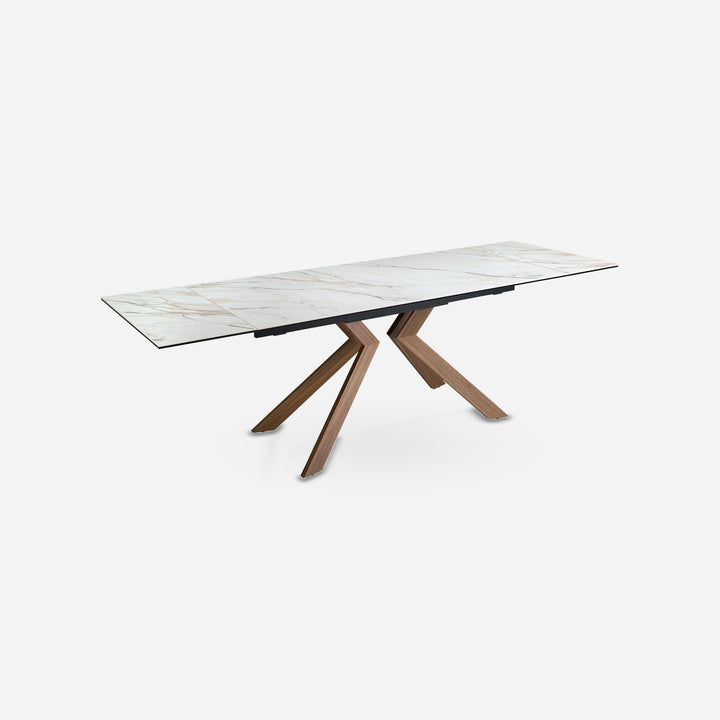 Mesa comedor extensible rectangular mármol porcelánico y acero efecto nogal sobre fondo gris de estudio