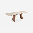 Mesa comedor extensible rectangular mármol porcelánico y acero efecto nogal sobre fondo gris de estudio