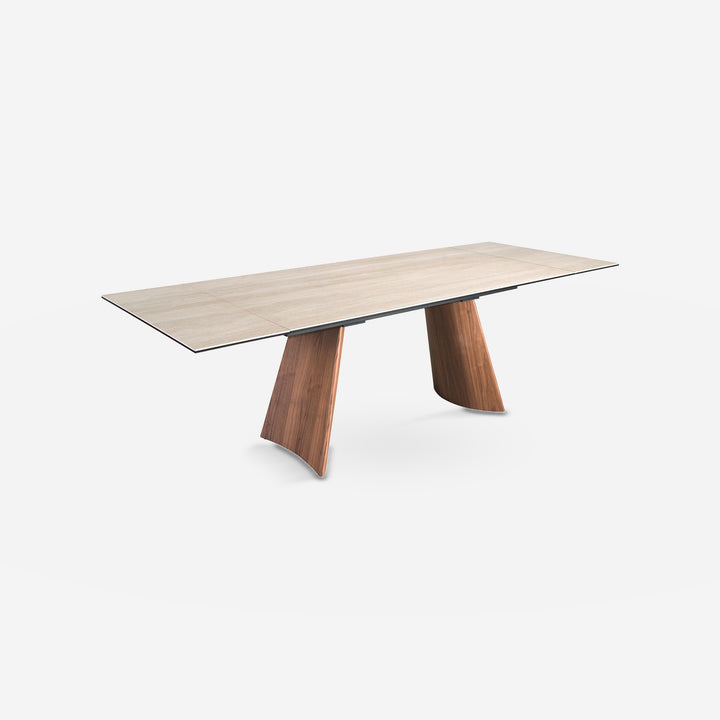 Mesa comedor extensible rectangular mármol porcelánico y acero efecto nogal sobre fondo gris de estudio