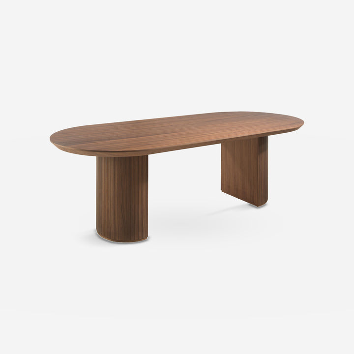 Mesa comedor ovalada medio punto nogal sobre fondo gris de estudio