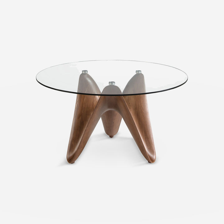 Mesa comedor redonda cristal templado y nogal sobre fondo gris de estudio