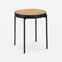 Mesa rincón redonda rattan, madera negra y acero negro sobre fondo gris de estudio