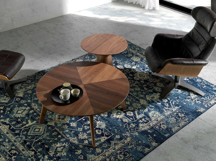 ottoman giratorio de piel vacuno color negro con detalles en madera y base metálica en cruz

