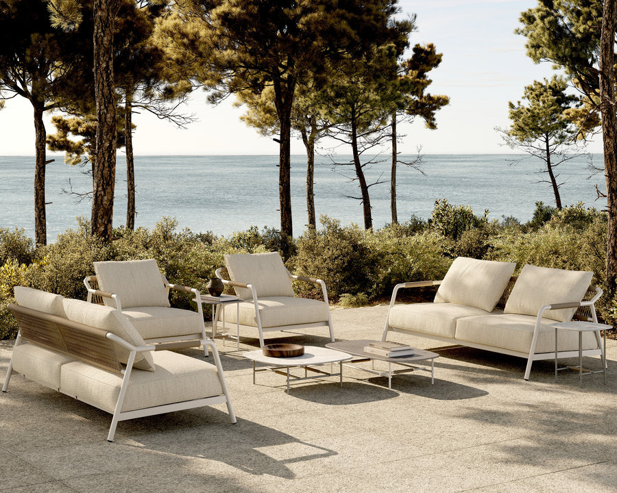 Terraza entre pinos frente al mar con sofás de exterior