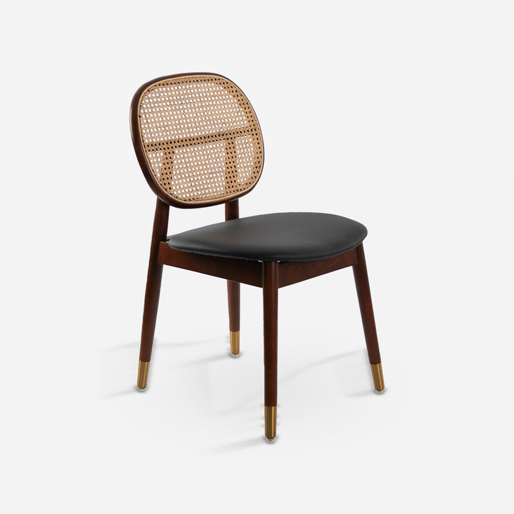 Silla rattan y polipiel negro sobre fondo gris de estudio