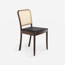 Silla rattan y polipiel negro sobre fondo gris de estudio