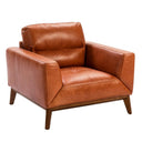 sillón de piel suave con respaldo bajo, brazos rectos y patas de madera en acabado natural
