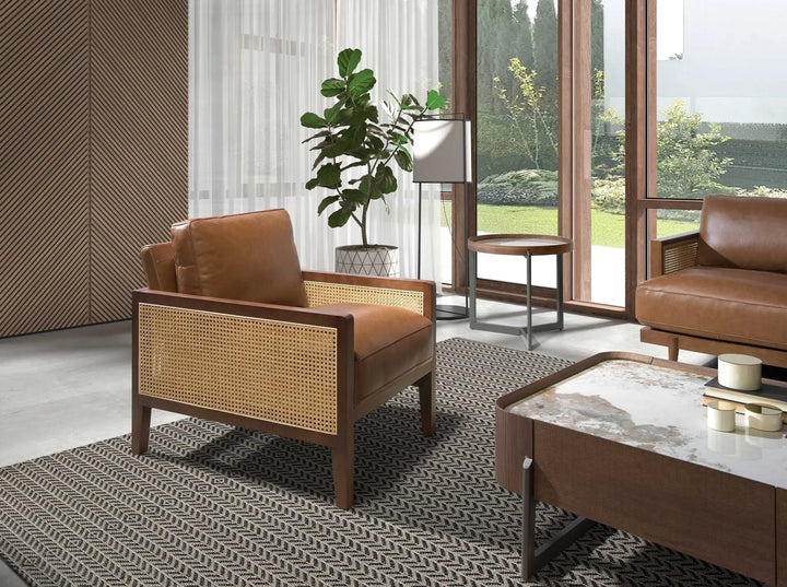 sillón en madera maciza con asiento de cuero marrón y laterales en rejilla de mimbre trenzado