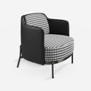 Sillón tela blanca y negra y polipiel negro sobre fondo gris de estudio