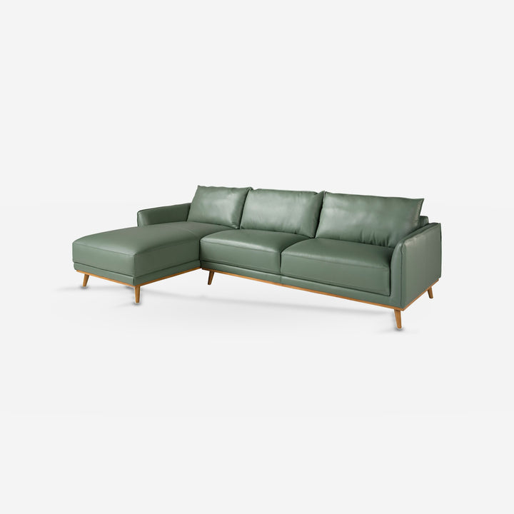 Sofá chaise longue piel verde sobre fondo gris de estudio