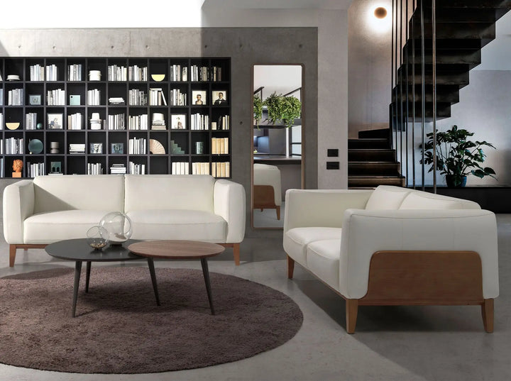 sofá estilo escandinavo con cojines blancos, base de madera clara y diseño funcional