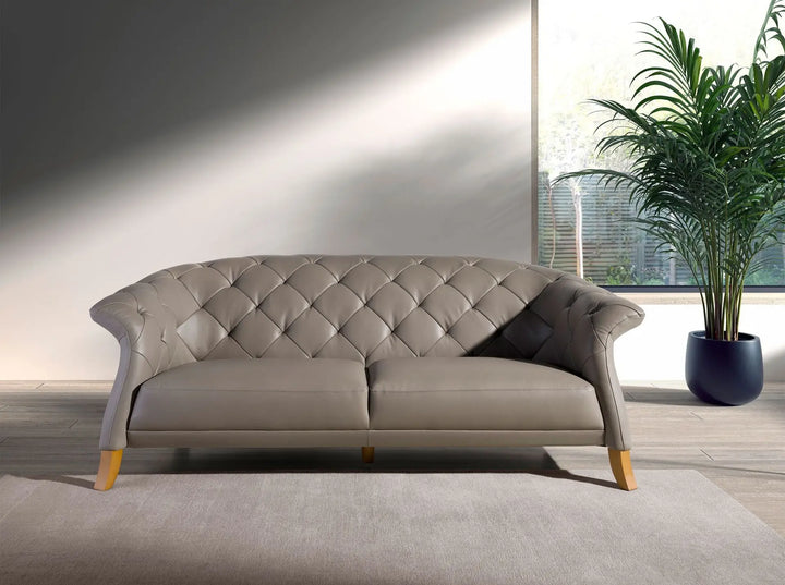 sofá estilo chester color gris con patas de madera claras y respaldo capitonado