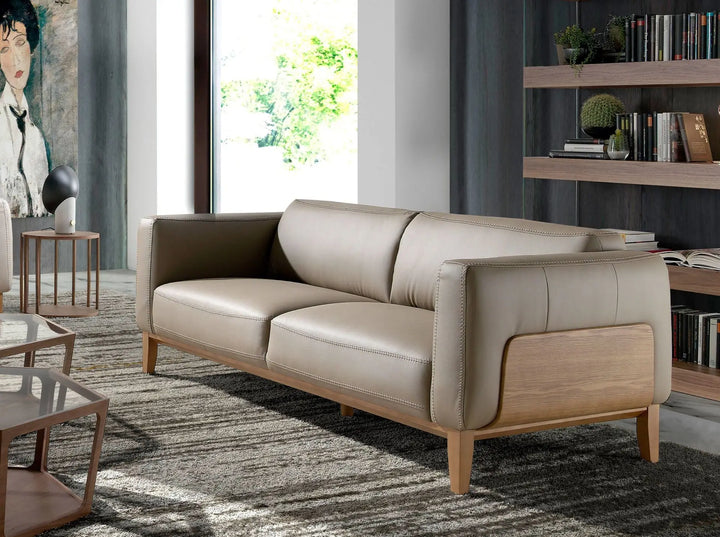 sofá elegante de piel gris con estructura en madera clara, estilo contemporáneo de dos plazas