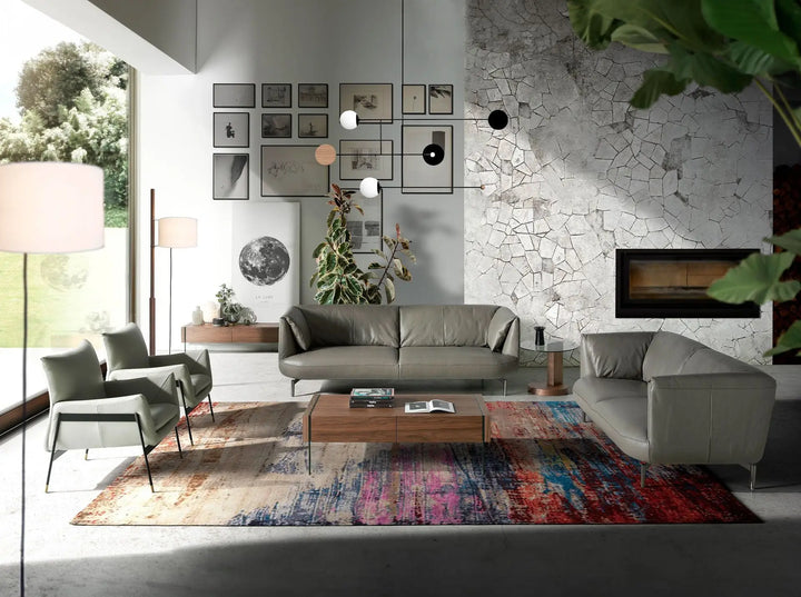 sofá estilo moderno en piel color gris verdoso con estructura metálica negra y líneas suaves